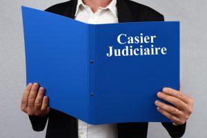 homme debout tenant un classeur avec une inscription casier judiciaire dans les mains