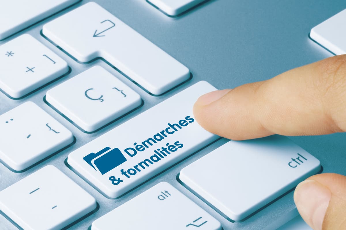 doigt appuyant sur la touche démarches et formalités d'un clavier 