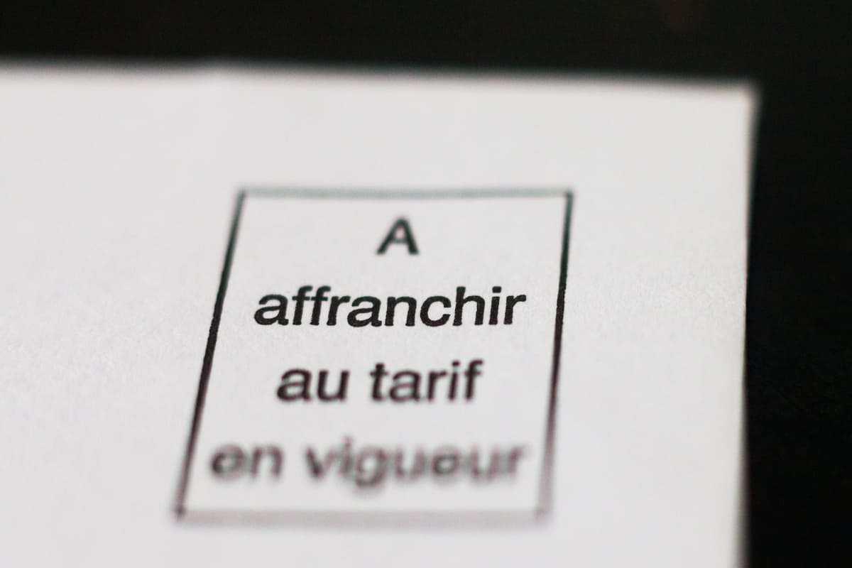 coin d'une enveloppe blanche avec la mention "A affranchir au tarif en vigueur" 