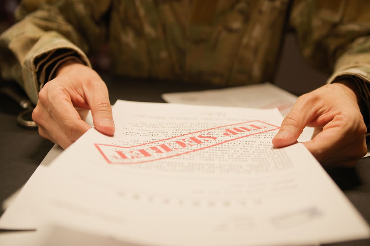 Militaire lisant un document top secret entre ses mains  