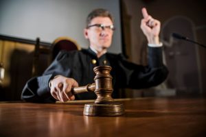 juge au tribunal tenant un marteau en bois et le frappant sur la table